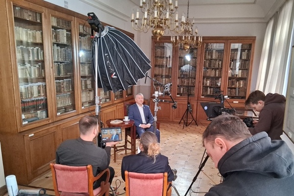 The room at Jazdów as a recording studio. Cameras, equipment, preparation for recording. People are sitting on chairs.