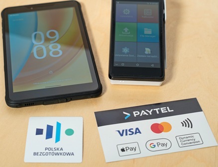 Zestaw do obsługi płatności mobilnych: terminal Paytel i tablet, prezentujące akceptację kart płatniczych oraz płatności telefonem w ramach programu Polska Bezgotówkowa.